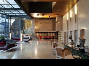 At check-in, Unique guests sip bubbly in comfy armchairs, while natural light pours into the lobby through glass walls and from a shaft above.